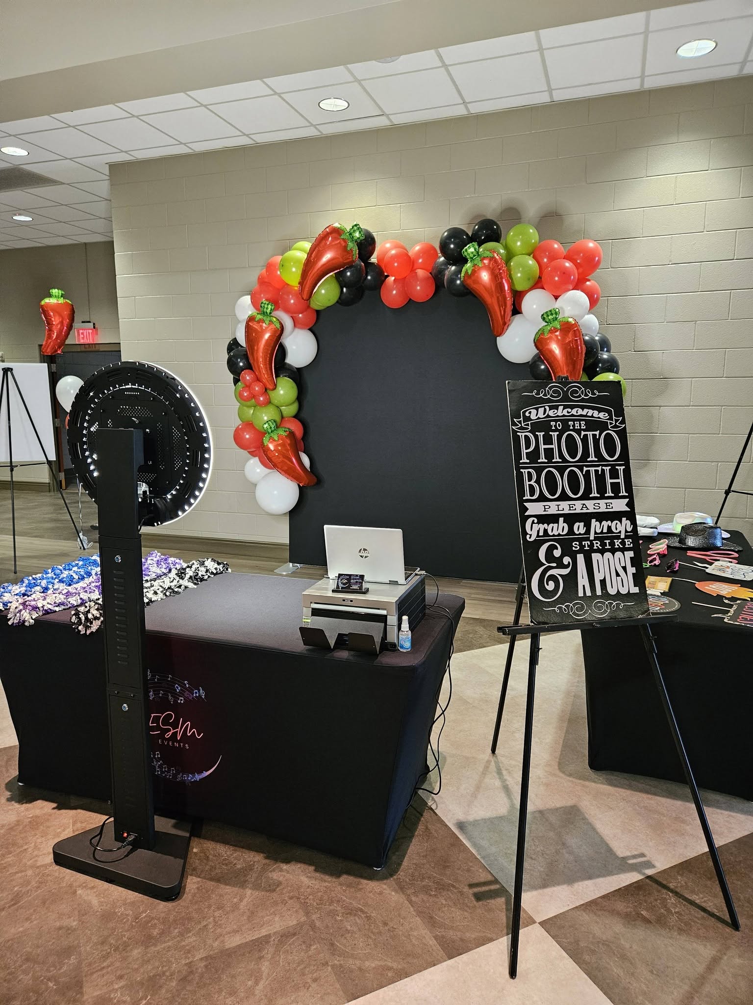 ESM photobooth with ring light, printer, props, and a balloon-framed backdrop